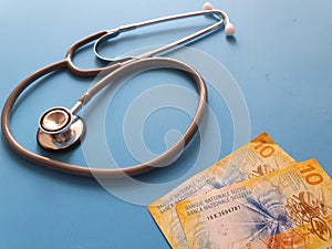 investment in health care, Swiss money and stethoscope for medical check