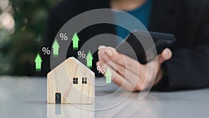 Investment planning concept. Businessman with wooden house and green upper arrow. Increase value of real estate. Income earning