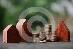 Investment in the real estate business. Money coin stack growing graph and wood house model. Loans for the purchase of residential