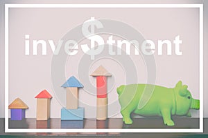 Investment text with toy block rising graph and piggy bank