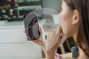 Investor analyzing exchange market, asian young business woman, girl trader on graphic charts on tablet, smartphone for trading