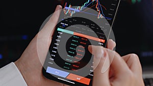 Investor checking Bitcoin, Ethereum and other altcoin cryptocurrency price index on mobile phone smartphone screen