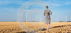 Investor in green energy looking at her wind turbines