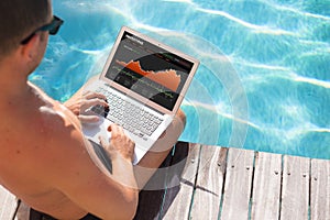 Investor looking at stock quotes on laptop by the pool