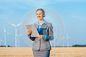Investor in wind turbines with computer evaluating her investment