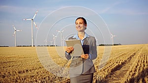 Investor in wind turbines with computer evaluating her investment on site