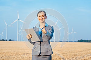 Investor in wind turbines with computer evaluating her investment photo