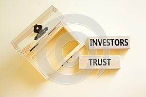 Investors trust symbol. Concept words Investors trust on wooden blocks on a beautiful white table white background. Empthy wooden