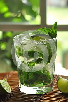 An invigorating mint mojito cocktail, garnished with fresh lime and mint leaves