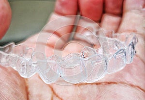 Invisalign or invisible braces, a orthodontic equipment on a hand. photo