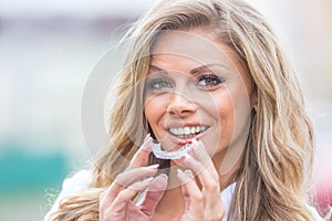 Invisalign orthodontics concept - Young attractive woman holding - using invisible braces or trainer photo