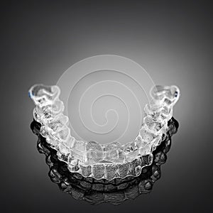 Invisible orthodontics cosmetic brackets on gradient background, tooth aligners, plastic braces. Modern teeth retainers created on