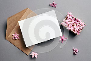 Invitation or greeting card mockup with envelope and hyacinth flowers on grey background