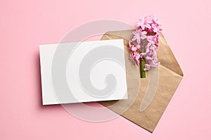Invitation or greeting card mockup with envelope and hyacinth flowers on pink background