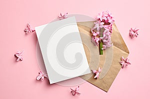 Invitation or greeting card mockup with envelope and hyacinth flowers on pink background