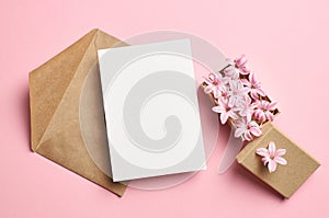 Invitation or greeting card mockup with envelope and hyacinth flowers on pink background