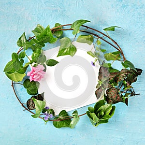 Invitation or greeting card square design template with a flat lay wreath of leaves and flower