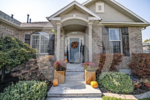 Inviting front entrance of a house with holloween ornaments at the front of the gray door