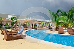 Inviting view of a curved wide open comfortable swimming pool with people relaxing and enjoying their time