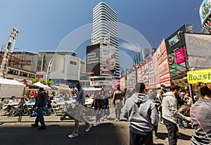 inviting view of many people at dundas square, walking, sitting, relaxing and enjoying their weekend time on sunny day