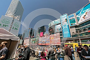 Inviting view of many people at dundas square, walking, sitting, relaxing and enjoying their weekend time