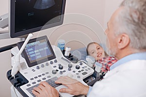 Involved aging practitioner using sonography equipment at work