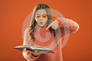 Involved in reading. Girl hold book orange background. Child show book notepad. Book store. Free book available read
