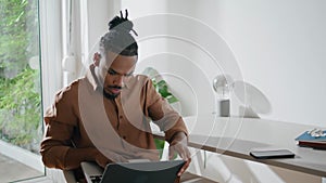 Involved student watching laptop workplace. Focused man looking screen at home