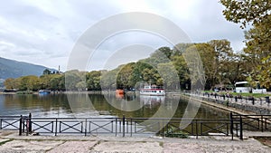 ioannina or giannena in autumn sesaon lake trees boats colors blue sky greece