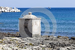 Ionian Sea. Small cubical building on the rocks. Blue sea