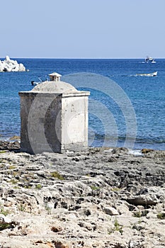 Ionian Sea. Small cubical building on the rocks. Blue sea