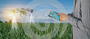 Iot smart agriculture industry 4.0 concept,Farmer use drone in precision farm use for spray a water, fertilizer or chemical to