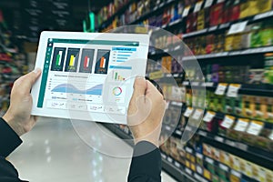 Iot smart retail in the futuristic concept, the retailer hold the tablet and use augmented reality technology monitor data of out