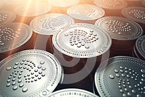 IOTA coins in blurry closeup with sunburst from above. IOTA growth concept. photo