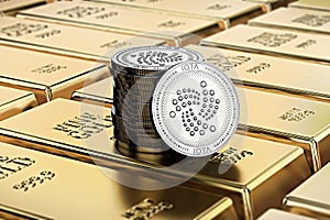 IOTA coins laying on stacked gold bars gold ingots rendered with shallow depth of field.