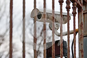 IP CCTV security camera and iron fence, urban cityscape