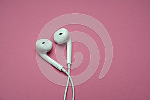 iPhone Apple Earpods, Airpods white earphones, headphones for listening to music and podcasts. Isolated pink background. Budapest