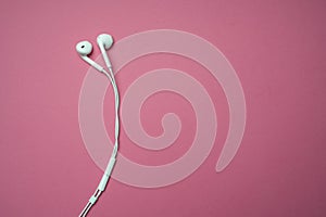 iPhone Apple Earpods, Airpods white earphones, headphones for listening to music and podcasts. Isolated pink background. Budapest