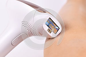 IPL `Intense Pulsed Light` laser hair removal home device next to bare leg