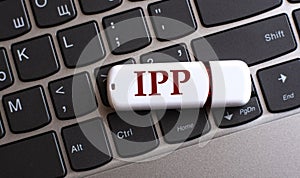 IPP - the word on a white flash drive, lying on a black laptop keyboard