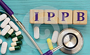 IPPB - acronym on wooden cubes on a blue background with a stethoscope and tablets