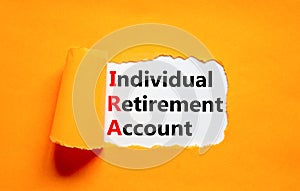 IRA individual retirement account symbol. Concept words IRA individual retirement account on white paper on beautiful orange