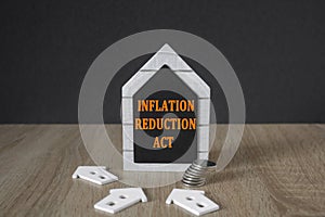 IRA inflation reduction act symbol. Concept words inflation reduction act on a black board in the shape of a house near miniature photo