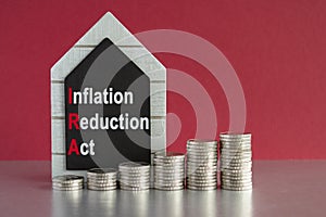 IRA inflation reduction act symbol. Concept words inflation reduction act on a black board. Silver coins arranged in a graph in photo