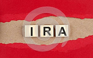 IRA word on wooden cubes on red torn paper , financial concept background