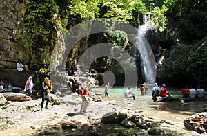 Sari, Iran - 18 July 2017: Waterfall at north of Iran, with iranian taking a swim with clothes and preparing barbacoe and iranian