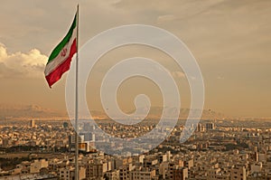 Iran Flag in the Wind Above Skyline of Tehran photo