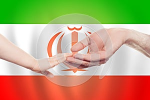 Irani baby and parent hands on the background of flag of Iran Help, aid, support, charity concept photo