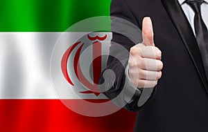 Irani concept. Businessman showing thumb up on the background of flag of Iran photo