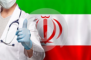 Irani doctor\'s hand showing thumb up positive gesture on flag of Iran background photo